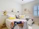 Bright bedroom with two twin beds, floating shelves, and colorful floral accents at 13422 Niti Dr, Hudson, FL 34669