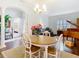 Bright dining area with wood floors, a round wood table, and a nearby grand piano at 13422 Niti Dr, Hudson, FL 34669