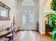 Elegant foyer featuring hardwood floors, decorative mirror, and glass paneled double doors at 13422 Niti Dr, Hudson, FL 34669