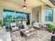 Covered patio with comfortable seating, ceiling fan, and view of the golf course at 13422 Niti Dr, Hudson, FL 34669