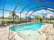 Inviting screened-in pool and spa surrounded by a brick-paved deck in backyard of property at 13422 Niti Dr, Hudson, FL 34669