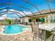 Screened-in pool area with outdoor dining, kitchen, bar and golf course views at 13422 Niti Dr, Hudson, FL 34669