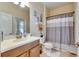 Bathroom featuring a toilet, sink, and shower with a curtain rod and grey-striped curtain at 13454 Graham Yarden Dr, Riverview, FL 33579