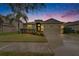 Charming home with a two-car garage and landscaped front yard highlighted by a beautiful sunset at 13454 Graham Yarden Dr, Riverview, FL 33579