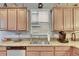 Kitchen sink area features granite countertops, wood cabinets, and a window providing natural light at 13454 Graham Yarden Dr, Riverview, FL 33579