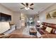 Cozy living room with a ceiling fan and views of the backyard through sliding glass doors at 13454 Graham Yarden Dr, Riverview, FL 33579