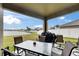 View of a covered patio area with outdoor seating, a barbecue grill, and a lake view at 13454 Graham Yarden Dr, Riverview, FL 33579