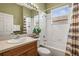 Bathroom featuring a single sink vanity, white tile surround tub and shower, and neutral walls at 16023 Golden Lakes Dr, Wimauma, FL 33598