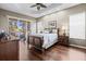 Main bedroom featuring hardwood floors, natural light, and sliding glass door to outdoor patio at 16023 Golden Lakes Dr, Wimauma, FL 33598