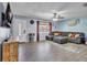 Spacious living room featuring tile floors, light blue walls, a gray couch, and abundant natural light at 17002 Melba Ln, Lutz, FL 33549