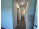 Hallway view to the bathroom and closet featuring neutral colored walls and flooring at 17048 James Trl, Parrish, FL 34219