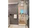 Bathroom featuring glass shower and patterned walls at 1712 Long Bow Ln, Clearwater, FL 33764