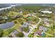 An aerial view showcases the property and neighborhood, near a lake and surrounded by trees at 17508 Isbell Ln, Odessa, FL 33556