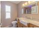 Modern bathroom featuring a stylish sink, vanity, and illuminated mirror, offering ample natural light at 17508 Isbell Ln, Odessa, FL 33556