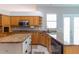 Kitchen featuring stainless appliances, granite countertops, wooden cabinets, and a breakfast bar at 17508 Isbell Ln, Odessa, FL 33556