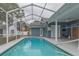A lovely blue swimming pool with screened enclosure, patio area, and connection to a detached building at 17508 Isbell Ln, Odessa, FL 33556