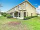 View of screened-in patio and manicured lawn with trimmed shrubs at 20462 Needletree Dr, Tampa, FL 33647