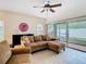 Comfortable living room featuring neutral tones, a ceiling fan, and sliding glass doors leading to a screened in patio at 20462 Needletree Dr, Tampa, FL 33647