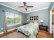 Bright bedroom features a ceiling fan, window overlooking trees, and a full-sized bed with floral bedding at 2138 Chianti Pl # 142, Palm Harbor, FL 34683