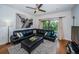 Bright living room with a black leather sofa, area rug, wood floors, and balcony access at 2138 Chianti Pl # 142, Palm Harbor, FL 34683