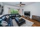 Spacious living room features a black leather sofa, wood floors, and a sliding door to the balcony at 2138 Chianti Pl # 142, Palm Harbor, FL 34683