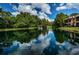 Picturesque pond with a fountain reflecting the sky, lush greenery, and building view at 2138 Chianti Pl # 142, Palm Harbor, FL 34683
