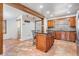 Kitchen with tile floors, a dark island, wood cabinetry, and a sink at 2502 Washington Rd, Valrico, FL 33594