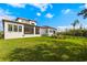 Large backyard featuring lush green lawn, screened in porch and black metal fence at 2630 Yellow Sundial Loop, Ruskin, FL 33570