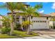 Charming home featuring a two-car garage, lush landscaping, and a welcoming entrance with ample curb appeal at 2630 Yellow Sundial Loop, Ruskin, FL 33570