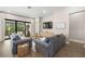 Living room features modern sofas, stylish decor, and sliding doors to the outdoor patio at 2630 Yellow Sundial Loop, Ruskin, FL 33570