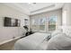 Bright main bedroom with tray ceiling, a peloton, and comfortable white bedding at 2630 Yellow Sundial Loop, Ruskin, FL 33570