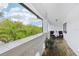 Outdoor balcony with tile flooring and a table set for two offering lush tropical views at 2710 Hibiscus W Dr, Belleair Beach, FL 33786