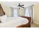 Bedroom featuring a large, wooden bedframe, ceiling fan, and soft natural light at 2710 Hibiscus W Dr, Belleair Beach, FL 33786