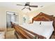 Bright bedroom featuring a large, wooden bedframe, closet, and ceiling fan at 2710 Hibiscus W Dr, Belleair Beach, FL 33786