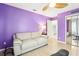 Bedroom with colorful purple walls, white sofa, and closet at 2710 Hibiscus W Dr, Belleair Beach, FL 33786
