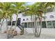 Charming two-story home with black door, and lush palm trees offering a tropical appeal at 2710 Hibiscus W Dr, Belleair Beach, FL 33786