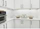 Modern white kitchen features sleek cabinetry, countertops, and stainless steel appliances at 2710 Hibiscus W Dr, Belleair Beach, FL 33786