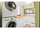 Functional laundry room with stacked washer and dryer and bright white cabinetry at 2710 Hibiscus W Dr, Belleair Beach, FL 33786