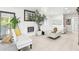 Bright living room with white furniture and modern fireplace at 2710 Hibiscus W Dr, Belleair Beach, FL 33786