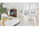 Open-concept living room with tiled floors and bar seating at 2710 Hibiscus W Dr, Belleair Beach, FL 33786