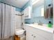 Bathroom featuring a shower-tub combination with white tile, a sink vanity, and blue walls at 2904 Lichen Ln # A, Clearwater, FL 33760