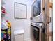 Compact laundry room with stacked washer and dryer, shelving, and a large organizational whiteboard at 2904 Lichen Ln # A, Clearwater, FL 33760