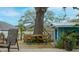 The backyard features a wooden deck with seating arrangements, complemented by a shady tree and lush vegetation at 345 12Th N Ave, Safety Harbor, FL 34695