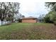 Large backyard with expansive lawn, mature trees, screened in porch, and a white picket fence at 3701 Barnhouse Pl, Valrico, FL 33596