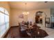 Formal dining room featuring a wood table, chandelier, and views of the living area at 3701 Barnhouse Pl, Valrico, FL 33596