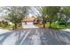 Charming single-story home features a three-car garage, stone accents, mature trees, and a well-manicured lawn at 3701 Barnhouse Pl, Valrico, FL 33596