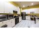 Bright kitchen with white cabinets, black appliances and a tile floor at 3701 Barnhouse Pl, Valrico, FL 33596