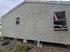 Side view of a raised home with stained siding and visible supports at 3716 N 57Th St, Tampa, FL 33619