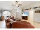 Cozy living room enhanced by natural light, a ceiling fan, and seamless transition to the entryway of this stunning home at 38944 Carr Dr, Zephyrhills, FL 33540