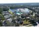 Aerial view of a beautiful community featuring a lake, tennis courts, and a luxurious pool area at 4507 Majestic Hill Loop, Brooksville, FL 34601